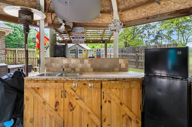 view of patio featuring area for grilling, fence, and a sink