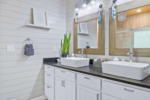 full bathroom with wood walls, a sink, and double vanity