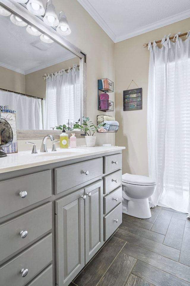 full bath with parquet floors, crown molding, vanity, and toilet