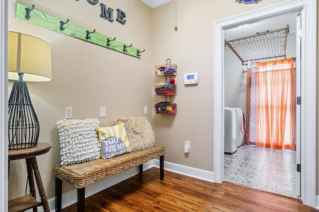 living area with baseboards, washer / dryer, and wood finished floors