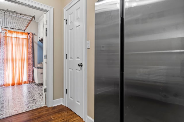 corridor featuring wood finished floors and baseboards