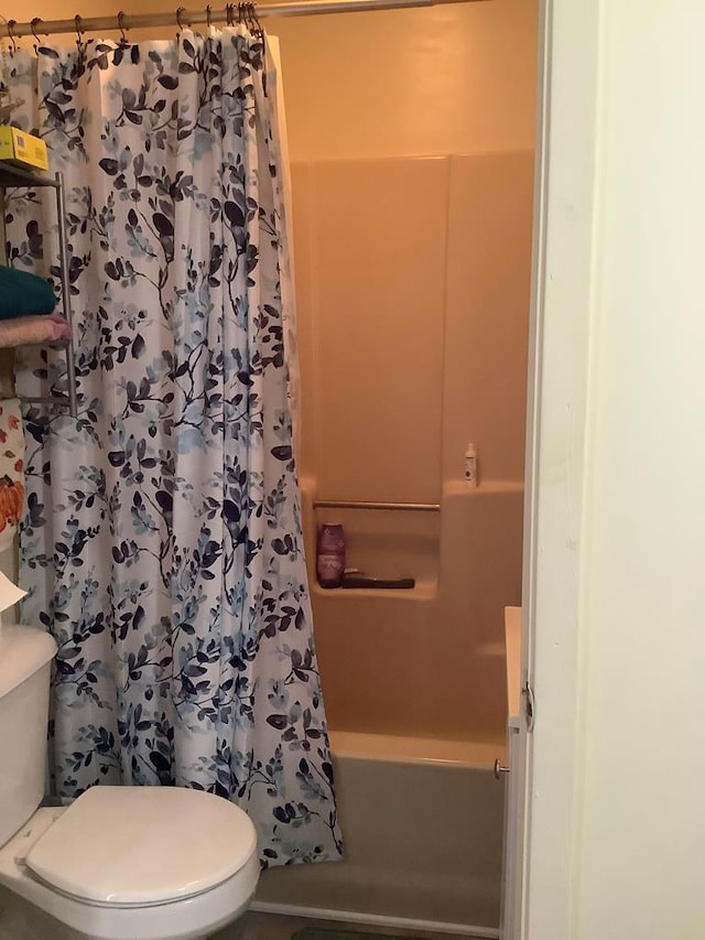 full bathroom with shower / bath combo with shower curtain and toilet