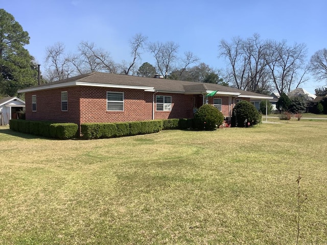 view of front facade with brick siding and a front lawn