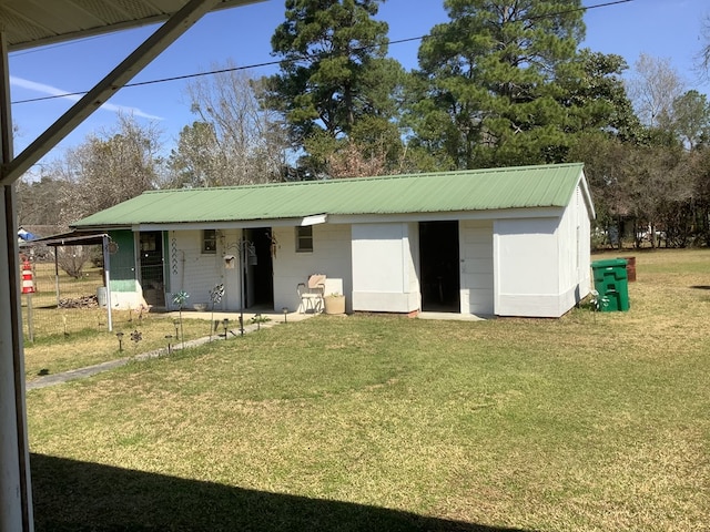 view of front of home with metal roof and a front lawn