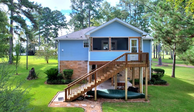 rear view of property featuring a sunroom and a yard