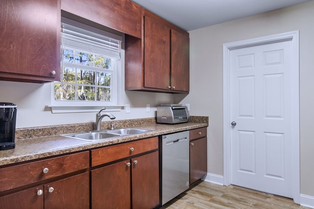 kitchen featuring stainless steel dishwasher, sink, and light hardwood / wood-style flooring