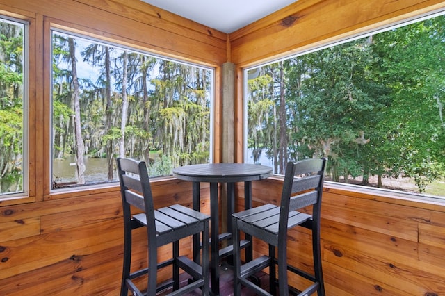 sunroom / solarium featuring plenty of natural light and a water view