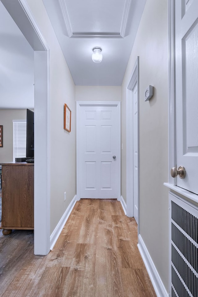 corridor featuring wood finished floors, visible vents, and baseboards