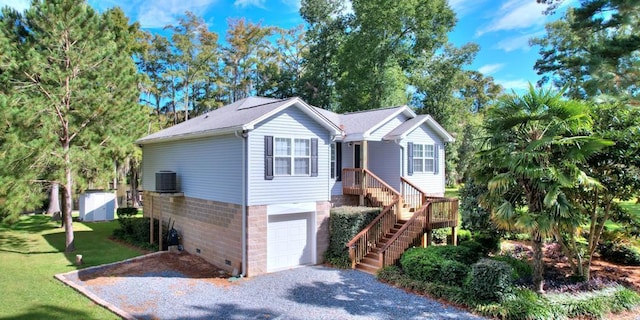 view of front of home with central AC unit, an attached garage, stairs, crawl space, and a front yard