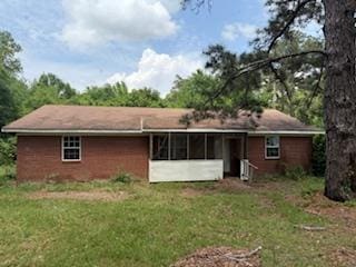 back of house with a lawn and a sunroom