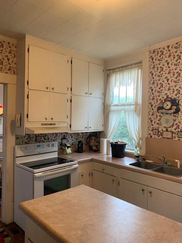 kitchen with under cabinet range hood, white electric range, a sink, white cabinets, and light countertops