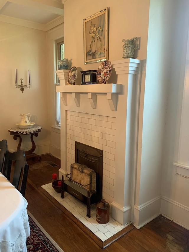 living area with ornamental molding, wood finished floors, and baseboards