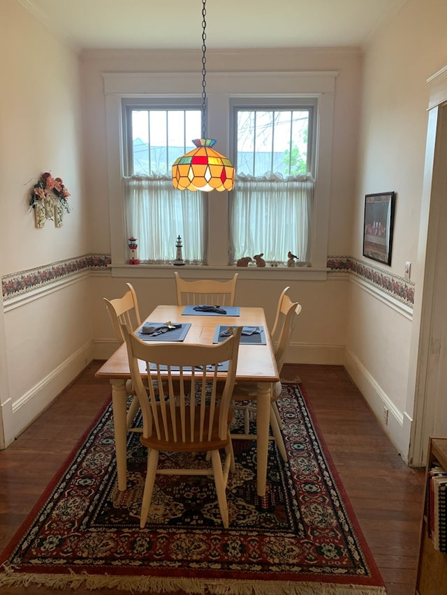 dining area with baseboards and wood finished floors