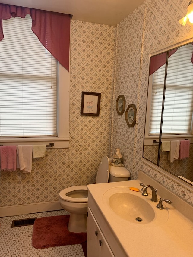 bathroom with visible vents, vanity, tile patterned flooring, and toilet