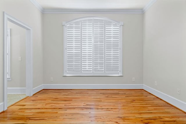 empty room featuring crown molding and light hardwood / wood-style floors