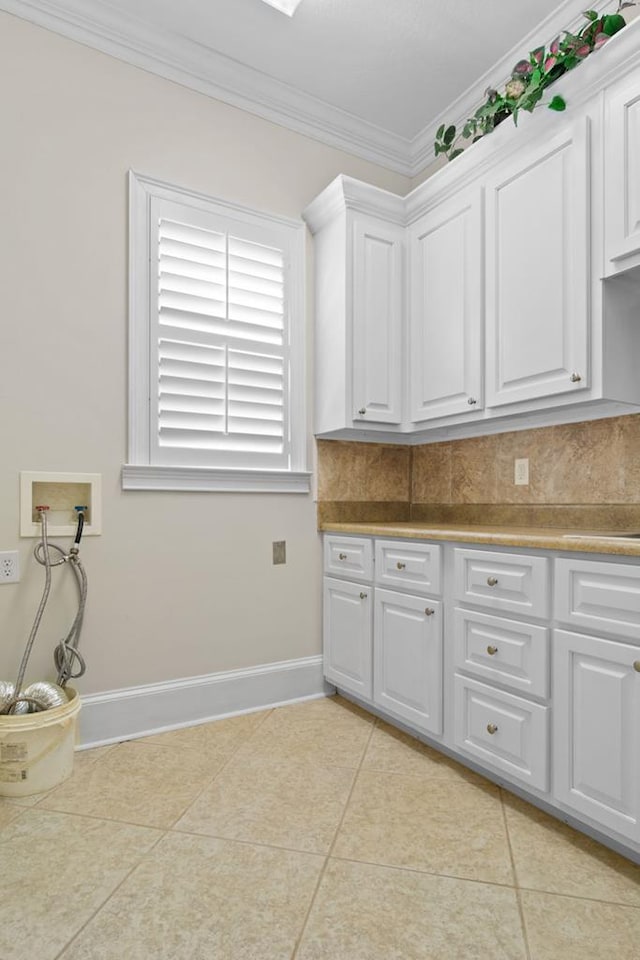 washroom featuring cabinets, washer hookup, light tile patterned floors, and ornamental molding