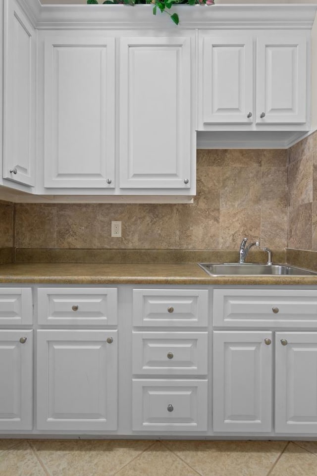 kitchen with sink, backsplash, and white cabinets