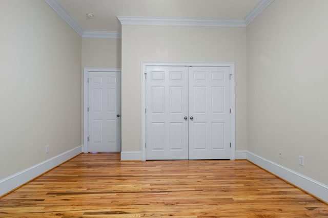 unfurnished bedroom with light wood-type flooring, ornamental molding, and a closet