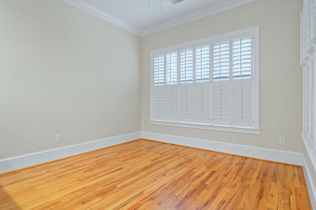 empty room with crown molding and light hardwood / wood-style flooring