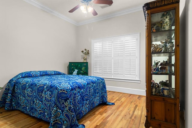 bedroom with ceiling fan, wood-type flooring, and ornamental molding