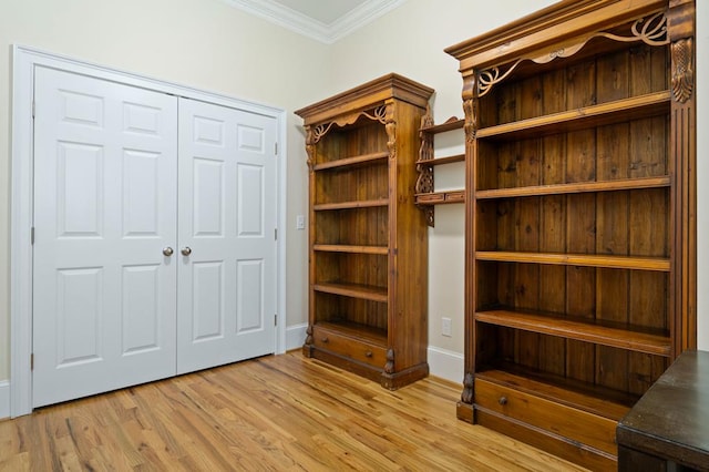 interior space featuring a closet, ornamental molding, and light hardwood / wood-style floors