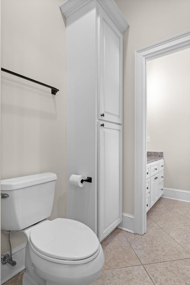 bathroom with toilet, tile patterned flooring, and vanity