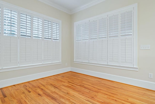 unfurnished room featuring crown molding, plenty of natural light, and wood-type flooring