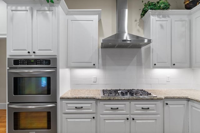 kitchen with white cabinets and wall chimney exhaust hood