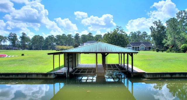 view of dock with a lawn and a water view