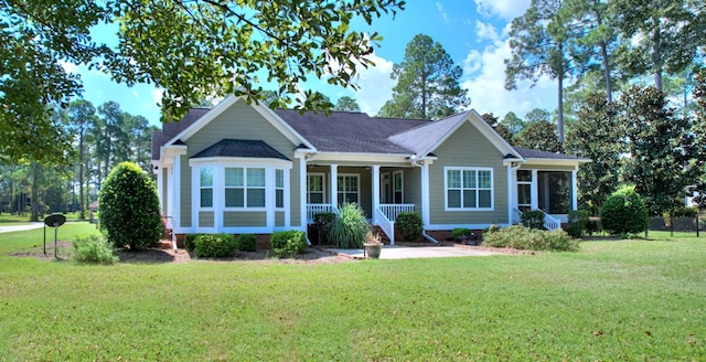 ranch-style home featuring covered porch and a front yard