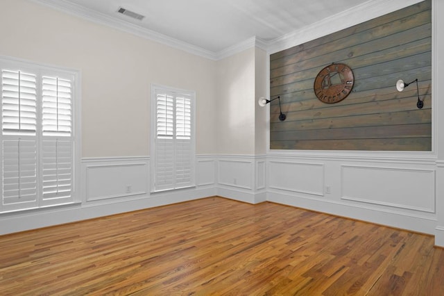 empty room featuring hardwood / wood-style floors and crown molding