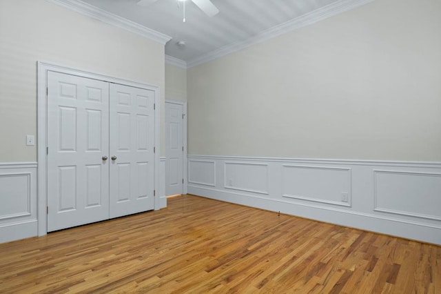 unfurnished bedroom featuring ceiling fan, light hardwood / wood-style floors, a closet, and crown molding