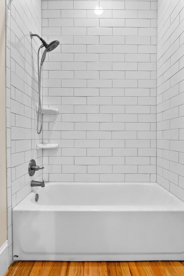 bathroom featuring hardwood / wood-style flooring and tiled shower / bath combo