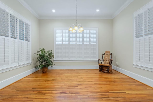 unfurnished room featuring crown molding, a chandelier, and light wood-type flooring