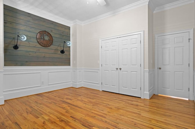 unfurnished bedroom with a closet, ceiling fan, ornamental molding, and light hardwood / wood-style floors