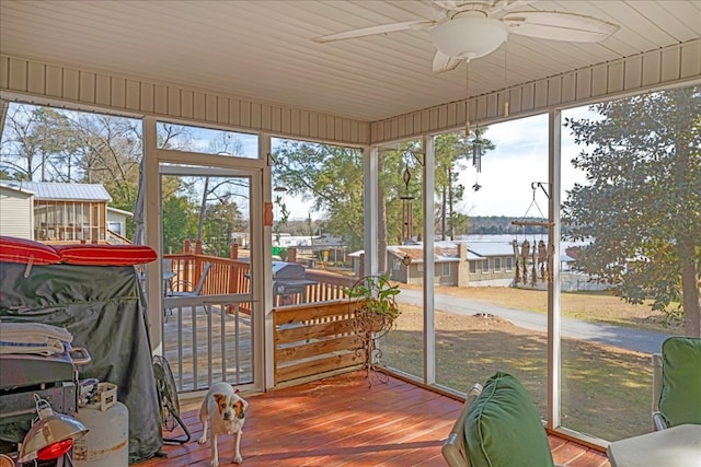 sunroom / solarium featuring a water view and ceiling fan