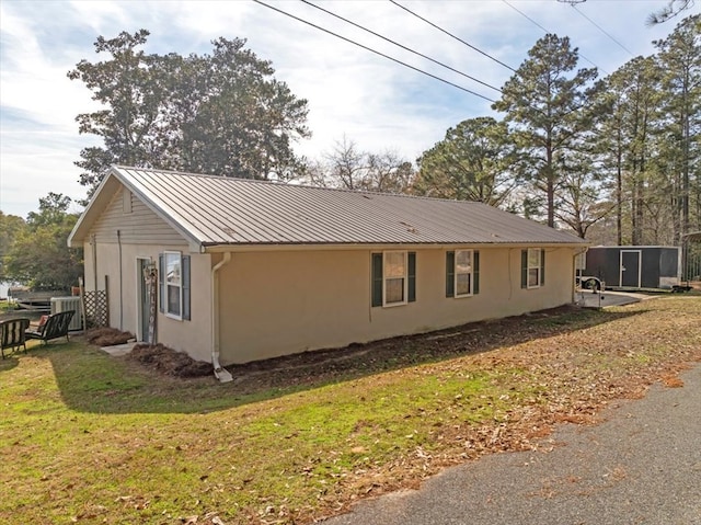 view of home's exterior featuring central AC unit and a lawn