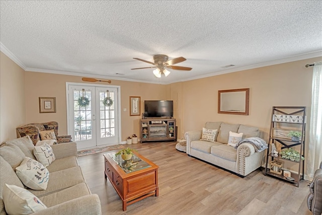 living room with french doors, ornamental molding, and light hardwood / wood-style flooring