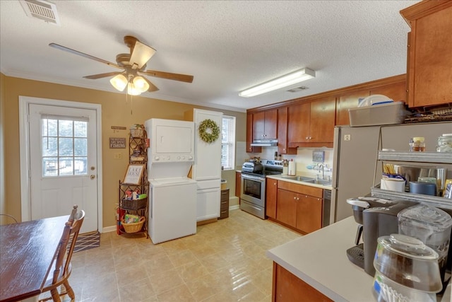 kitchen with stainless steel electric stove, stacked washing maching and dryer, sink, ornamental molding, and ceiling fan