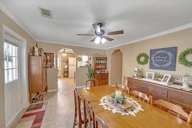 dining room featuring crown molding, ceiling fan, and a textured ceiling