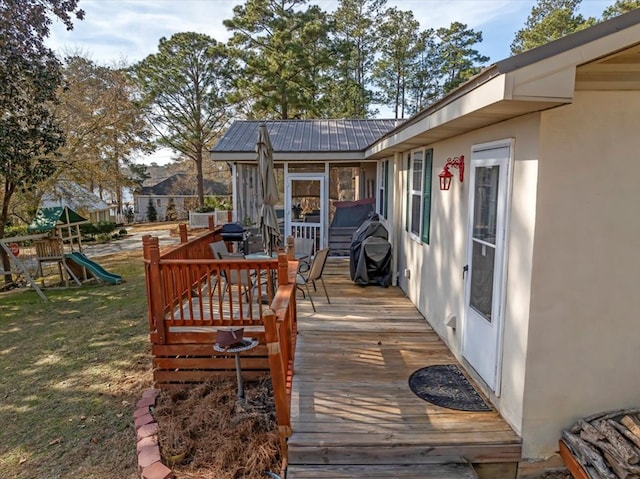 deck featuring a playground and a yard