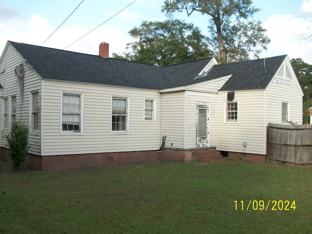 back of house with a lawn