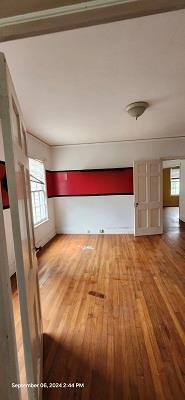 unfurnished living room featuring ornamental molding and wood-type flooring