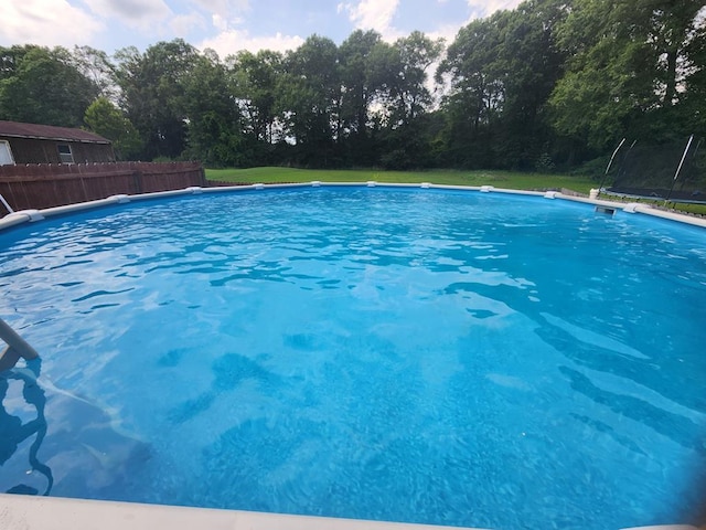 view of swimming pool with a trampoline