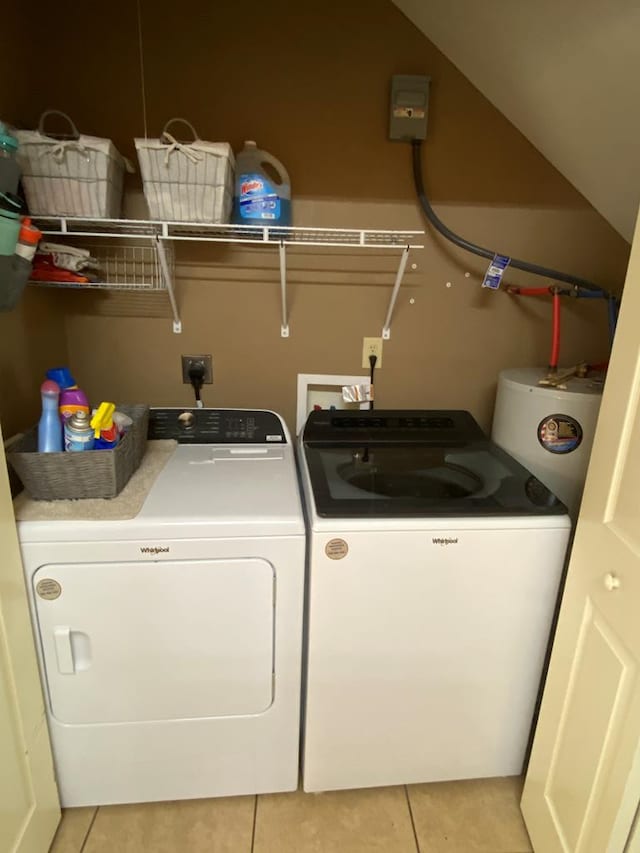 laundry area featuring water heater, light tile patterned floors, and washer and dryer