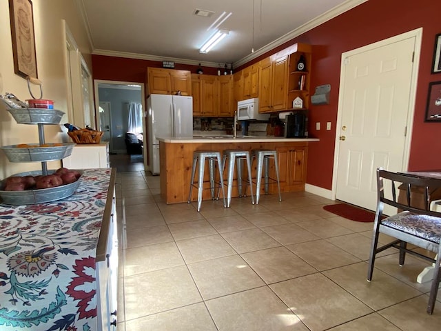 kitchen featuring white appliances, tasteful backsplash, ornamental molding, kitchen peninsula, and light tile patterned flooring