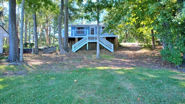 rear view of house with a deck and a yard