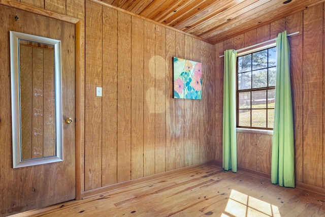 unfurnished room with hardwood / wood-style flooring, wood ceiling, and wooden walls