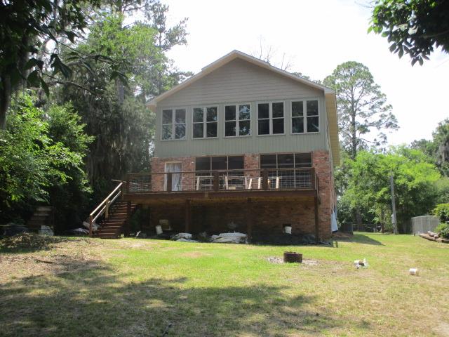 375 Flintside Dr, Cobb, GA 31735 - back of property with brick siding, stairs, and a lawn