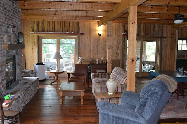375 Flintside Dr, Cobb, GA 31735 - living area featuring beamed ceiling, wooden walls, hardwood / wood-style floors, a fireplace, and a ceiling fan